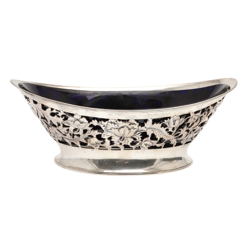 28 - AN EDWARDIAN SILVER FRUIT BOWL. Of nevette form, the sides decorated with pierced foliate and floral... 
