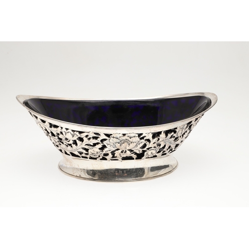 28 - AN EDWARDIAN SILVER FRUIT BOWL. Of nevette form, the sides decorated with pierced foliate and floral... 