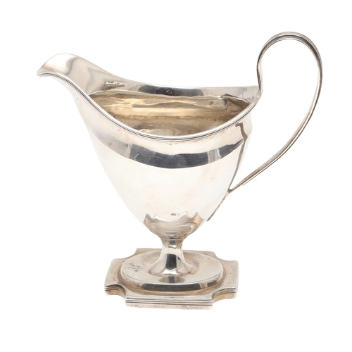 29 - A GEORGE III SILVER HELMET SHAPED CREAM JUG. The helmet shape bowl with handle, on a rectangular bas... 