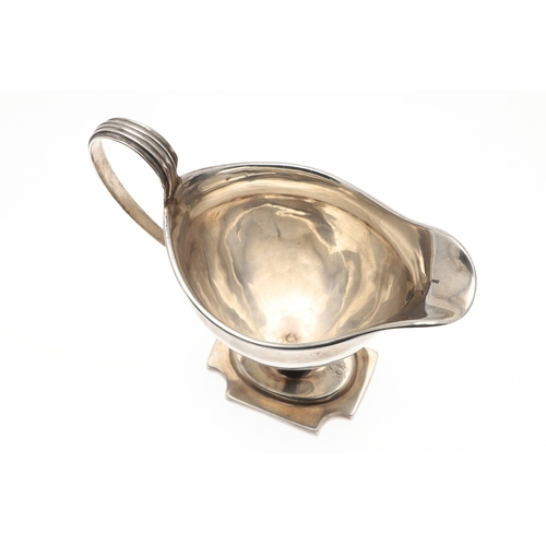 29 - A GEORGE III SILVER HELMET SHAPED CREAM JUG. The helmet shape bowl with handle, on a rectangular bas... 