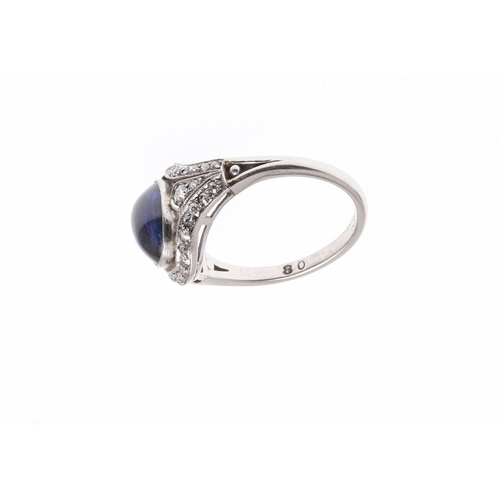 310 - AN EDWARDIAN SAPPHIRE AND DIAMOND RING. set with an oval-shaped cabochon sapphire within a surround ... 