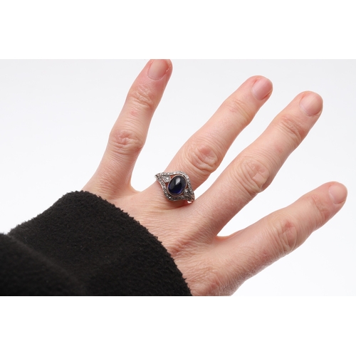 310 - AN EDWARDIAN SAPPHIRE AND DIAMOND RING. set with an oval-shaped cabochon sapphire within a surround ... 