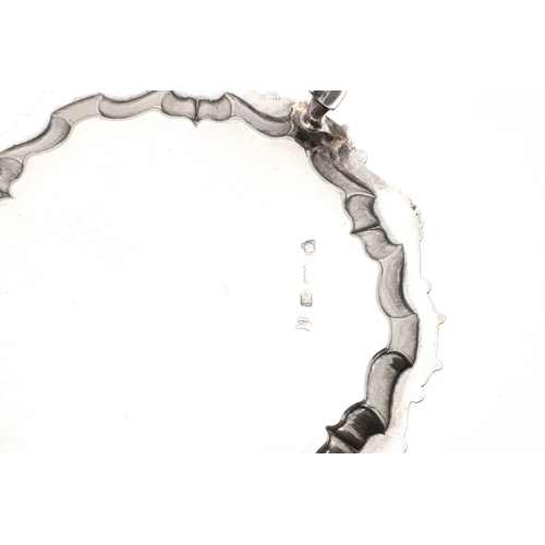 35 - A PAIR OF GEORGE II SILVER WAITERS. Of circular form, the cast border decorated with scrolls and she... 