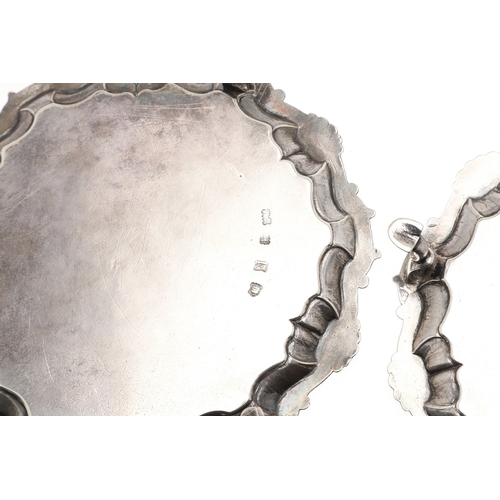 35 - A PAIR OF GEORGE II SILVER WAITERS. Of circular form, the cast border decorated with scrolls and she... 