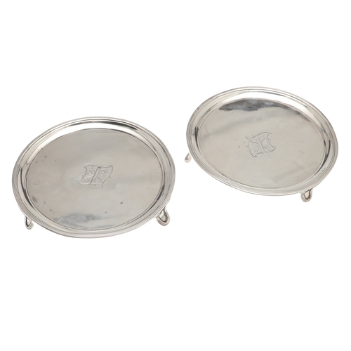 37 - A PAIR OF SMALL GEORGE III SILVER SALVERS. Of circular form with central engraved crest, raised on t... 