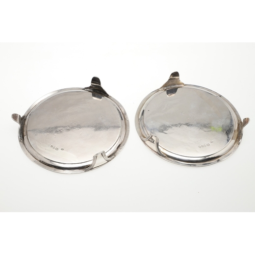 37 - A PAIR OF SMALL GEORGE III SILVER SALVERS. Of circular form with central engraved crest, raised on t... 