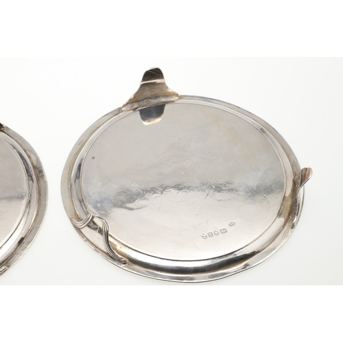 37 - A PAIR OF SMALL GEORGE III SILVER SALVERS. Of circular form with central engraved crest, raised on t... 