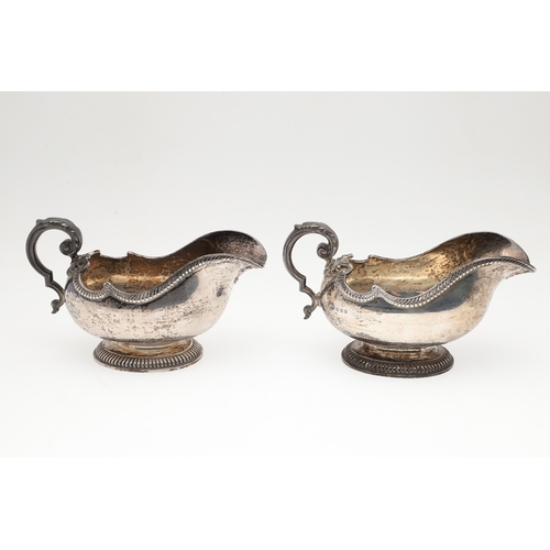 45 - A PAIR OF GEORGE V SILVER SAUCE BOATS. Featuring deep oval shaped bowls with broad spouts, gadrooned... 