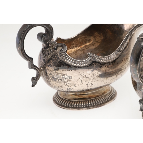 45 - A PAIR OF GEORGE V SILVER SAUCE BOATS. Featuring deep oval shaped bowls with broad spouts, gadrooned... 