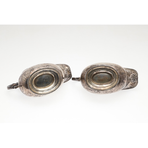 45 - A PAIR OF GEORGE V SILVER SAUCE BOATS. Featuring deep oval shaped bowls with broad spouts, gadrooned... 