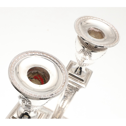 60 - A PAIR OF VICTORIAN SILVER CANDLESTICKS. Each candlestick with a beaded circular sconce, urn shaped ... 