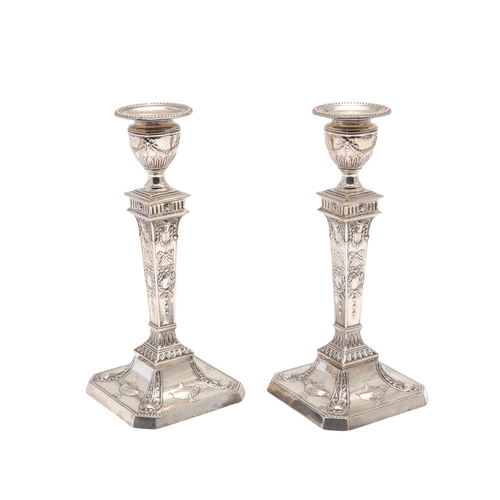 61 - A PAIR OF EARLY 20TH CENTURY FILLED SILVER CANDLESTICKS. In the Adam style, each candlestick being d... 