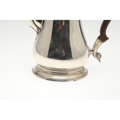 74 - A LATE GEORGE II SILVER COFFEE POT. Of plain baluster form, with scroll handle and round foot, the l... 