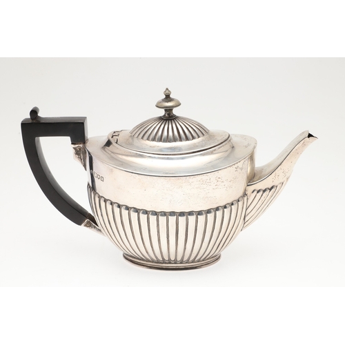 82 - AN EDWARDIAN SILVER TEAPOT. With gadrooned decoration and ebonised handle, hallmarked Edward Barnard... 