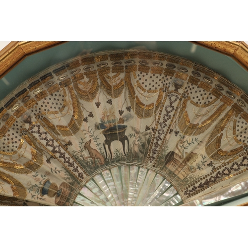 429 - A REGENCY MOTHER OF PEARL AND SEQUINNED FAN. painted with Classical decoration of urns, doves, a hou... 