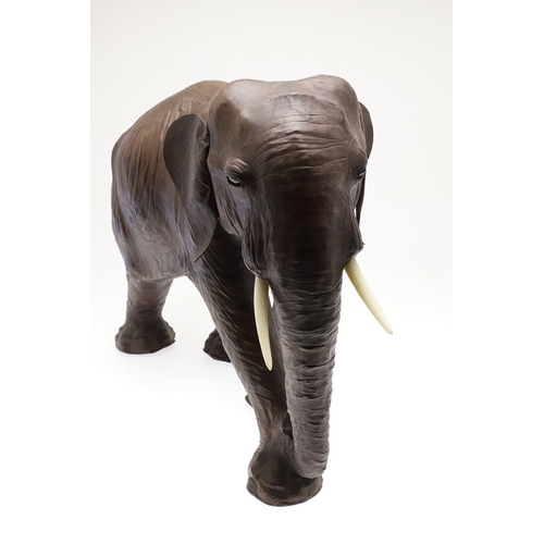 446 - A LARGE LEATHER COVERED ELEPHANT, IN THE STYLE OF OMERSA FOR LIBERTY. with moveable soft leather ear... 