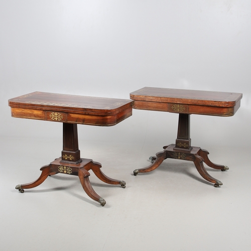 475 - A PAIR OF REGENCY ROSEWOOD AND BRASS INLAID GAMES TABLES. with D-end baize lined swivel tops, inlaid... 