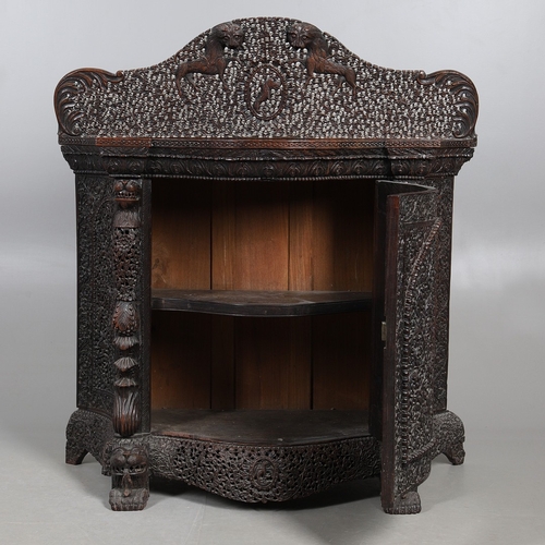 521 - A 19TH CENTURY BURMESE HARDWOOD SIDE CABINET. the raised back over a serpentine front and concave si... 