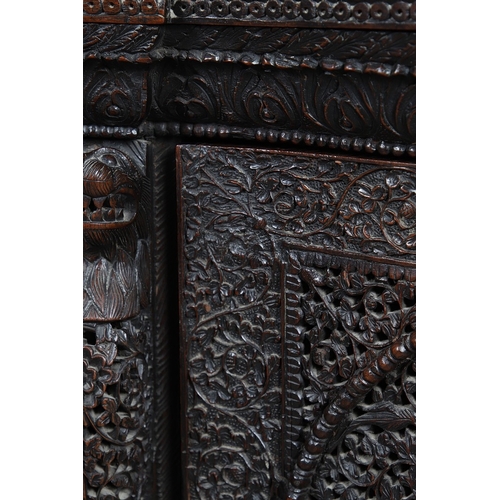 521 - A 19TH CENTURY BURMESE HARDWOOD SIDE CABINET. the raised back over a serpentine front and concave si... 