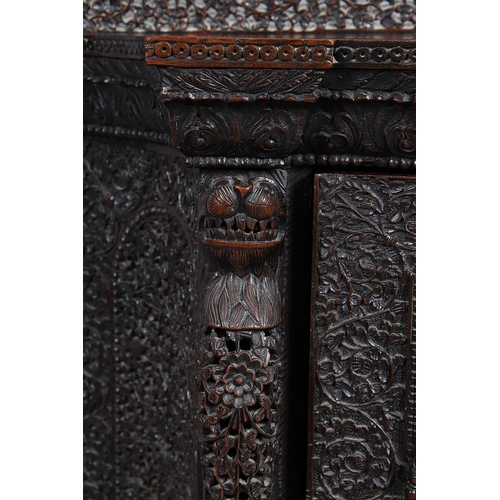 521 - A 19TH CENTURY BURMESE HARDWOOD SIDE CABINET. the raised back over a serpentine front and concave si... 