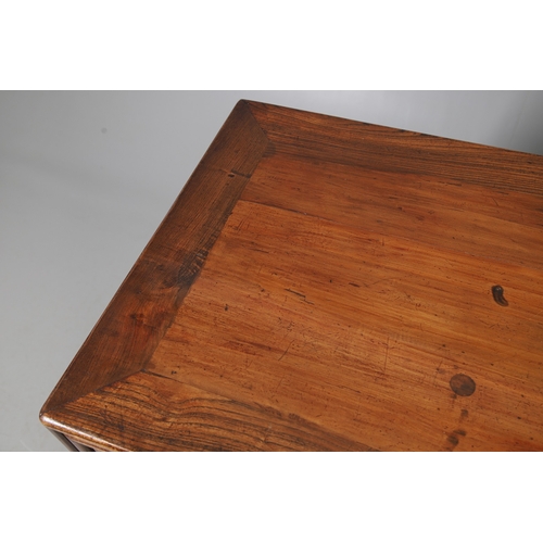 523 - A LATE 19TH/EARLY 20TH CENTURY CHINESE DONGSHAN ELM DESK. with three deep drawers to an open framewo... 