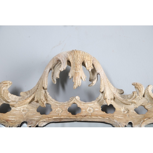 534 - AN 18TH CENTURY CARVED LIMEWOOD WALL MIRROR. the carved foliate and C-scroll surround to a later pla... 