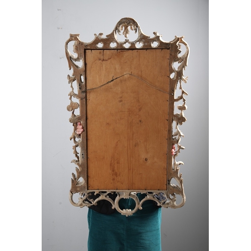 534 - AN 18TH CENTURY CARVED LIMEWOOD WALL MIRROR. the carved foliate and C-scroll surround to a later pla... 