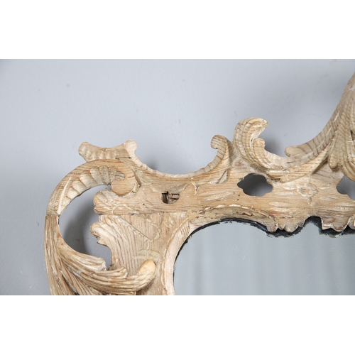534 - AN 18TH CENTURY CARVED LIMEWOOD WALL MIRROR. the carved foliate and C-scroll surround to a later pla... 