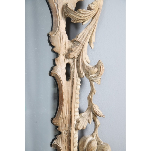 534 - AN 18TH CENTURY CARVED LIMEWOOD WALL MIRROR. the carved foliate and C-scroll surround to a later pla... 