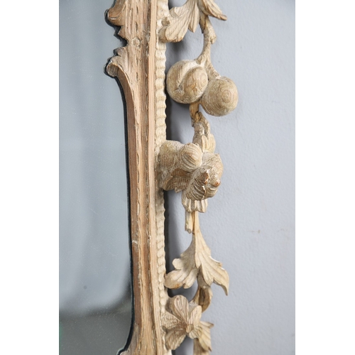 534 - AN 18TH CENTURY CARVED LIMEWOOD WALL MIRROR. the carved foliate and C-scroll surround to a later pla... 