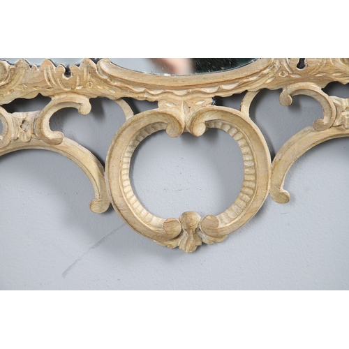 534 - AN 18TH CENTURY CARVED LIMEWOOD WALL MIRROR. the carved foliate and C-scroll surround to a later pla... 