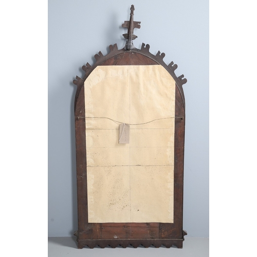 543 - A LATE 19TH CENTURY 'GOTHIC' OAK AND BRASS WALL MIRROR. the carved arched surround to pressed brass ... 