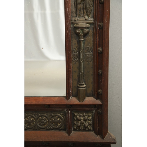 543 - A LATE 19TH CENTURY 'GOTHIC' OAK AND BRASS WALL MIRROR. the carved arched surround to pressed brass ... 