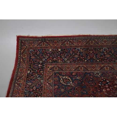 545 - A MASHAD CARPET, KHORASAN, CIRCA 1925. The raspberry field richly decorated with vines around a flow... 