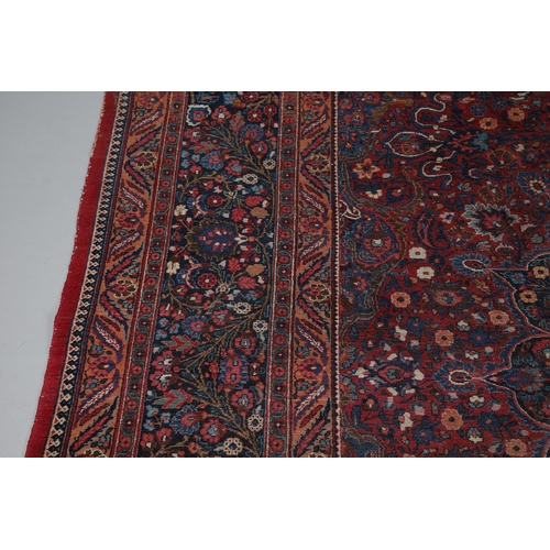545 - A MASHAD CARPET, KHORASAN, CIRCA 1925. The raspberry field richly decorated with vines around a flow... 