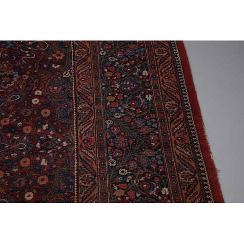 545 - A MASHAD CARPET, KHORASAN, CIRCA 1925. The raspberry field richly decorated with vines around a flow... 