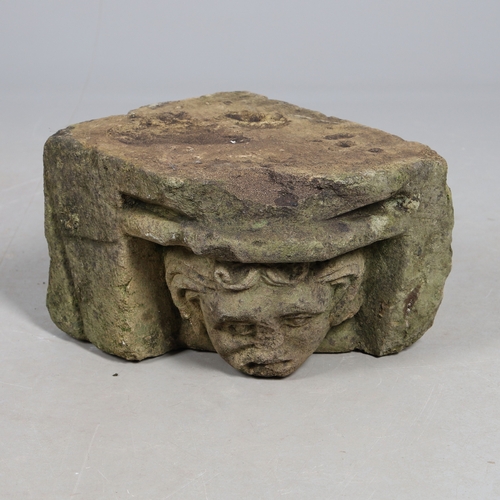 554 - A MEDIEVAL STONE CORBEL. possibly 15th century, carved with a head of a curly haired man, height 22c... 