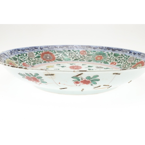 680 - LARGE CHINESE FAMILLE VERTE DISH. Kangxi period (1662-1722), the large shallow dish painted with a v... 