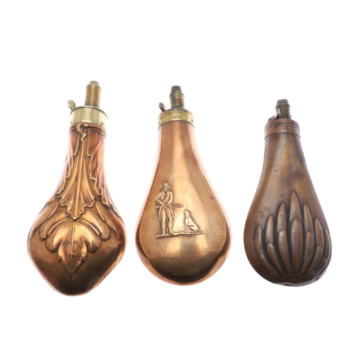 65 - A COLLECTION OF THREE LARGE COPPER BODIED POWDER FLASKS. A copper bodied powder flask, the body deco... 