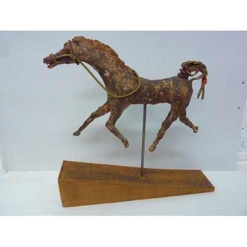 426 - A CAST SCULPTURE OF A RACE HORSE APPROX. HEIGHT 14 INS. X 13. INS LENGTH, ON A METAL STAND ON A WOOD... 