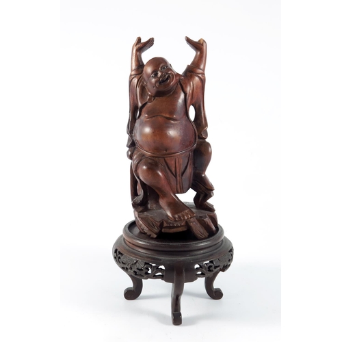 452 - EARLY 20TH CENTURY, POSSIBLY JAPANESE CARVED WOOD FIGURE OF THE LAUGHING BUDDHA (HOTEI) ON HARD WOOD... 