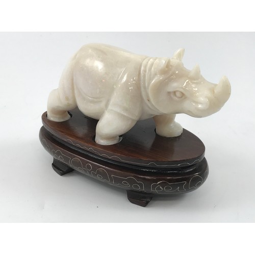 1974 - OPAL CARVING DEPICTING A RHINO APPROX 5.5 cm ON HARDWOOD STAND