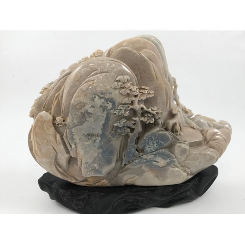 1978 - VERY LARGE OPAL CARVING DEPICTING A MOUNTAIN SCENE APPROX 13 cm ON A HARDWOOD STAND