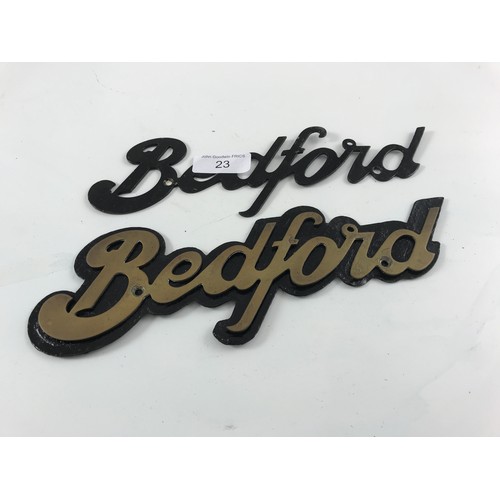 23 - PAIR OF BEDFORD VEHICLE RADIATOR BADGES 1 IN BLACK AND 1 IN A BRASS COLOUR WITH BLACK BACKGROUND