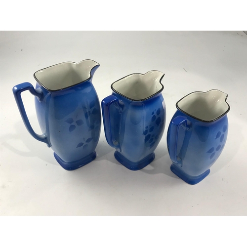 860 - SET OF 3 GRADUATED SYLVAC JUGS DECORATED WITH FLORAL AND BIRD DECORATION