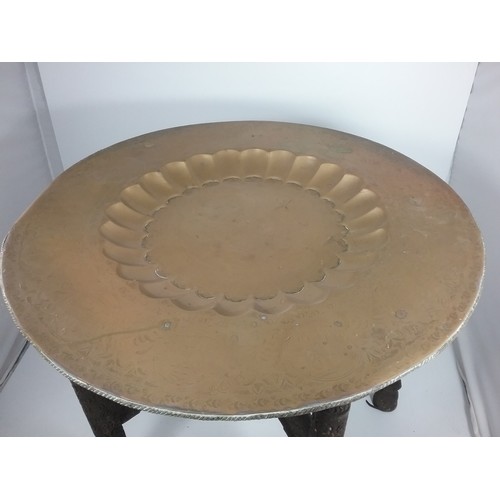 95 - INDIAN BRASS TRAY TOP TABLE WITH CARVED WOODEN FOLDING BASE TRAY TOP APPROX. 76 cms DIAMETER