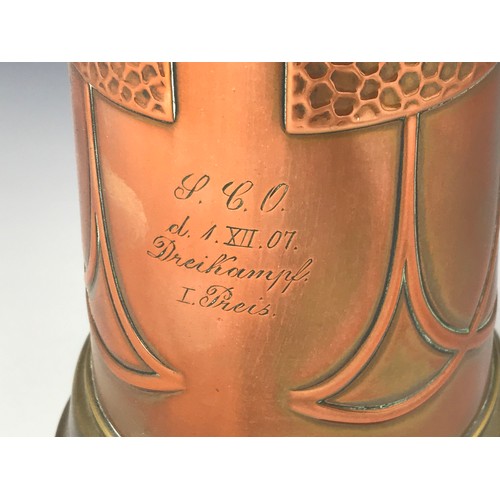 416 - ARTS AND CRAFTS COPPER AND BRASS JUG WITH EMBOSSED AND PLANISHED DECORATION AND INSCRIPTION