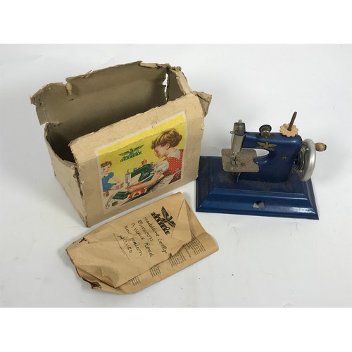 194 - CHILD’S CASIGE TIN PLATE SEWING MACHINE IN ORIGINAL BOX WITH INSTRUCTIONS