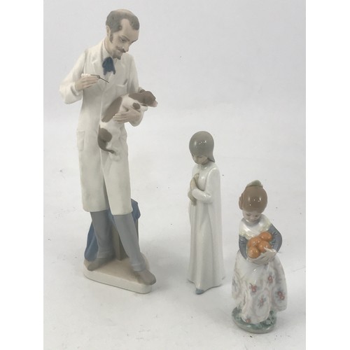 145 - LLADRO FIGURE OF A VET TREATING A DOG, ONE OTHER COLOURED LLADRO FIGURE AND ONE OTHER