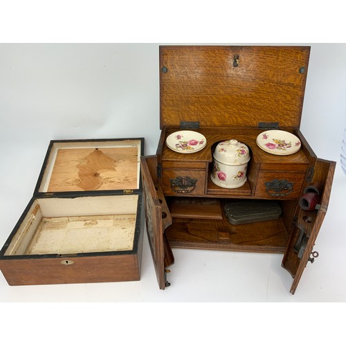 395 - SMALL NICE OAK CASED SMOKER'S CABINET WITH HINGED AND CARVED FRONT PANELS A WOODEN BOX